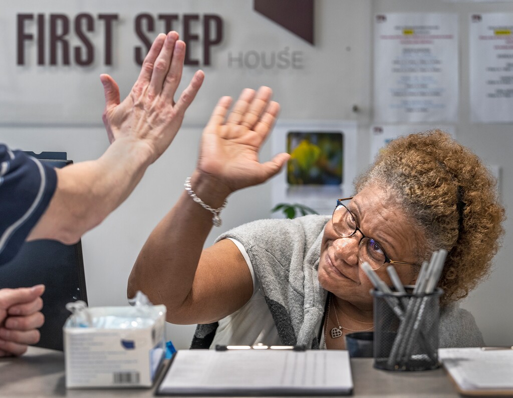 (Leah Hogsten | The Salt Lake Tribune) Paulette Anderson, admissions coordinator for First Step House, high-fives a new tenant upon their first meeting, Oct. 4, 2022. ""Everybody who walks through this door is family," said Anderson of the workplace she said is the best job she's ever had. The facility serves over 1,200 individuals a year, who arrive with very little resources, lack of support and numerous barriers to overcome. First Step House provides all encompassing care and treatment for people diagnosed with a substance use disorder, mental health conditions, Veterans, those involved in the criminal justice system, people with low to no income, and those who have unstable or no housing.Ê