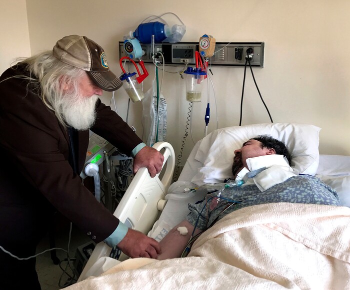 In this April 18, 2017, photo, Walter Wenger visits his severely disabled son, Steven, in a hospital in Kingston, N.Y, where he was moved after maggots were twice found in the area around his breathing tube while living in a state group home. The Associated Press obtained a confidential report on the state investigation that determined the 2016 infestations at the group home in Rome, N.Y., were the result of neglect by caregivers. In most states, details of abuse and neglect investigations in state-regulated institutions for the disabled are almost never made public. (AP Photo/David Klepper)