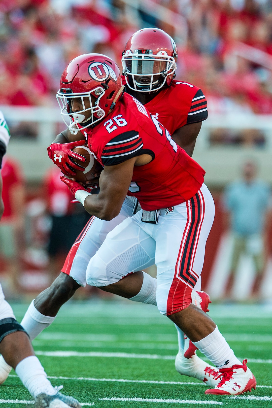 (Chris Detrick  |  The Salt Lake Tribune)  Utah Utes quarterback Tyler Huntley (1)  hands off to Utah Utes running back Jordan Howard (26) during the game at Rice-Eccles Stadium Thursday, August 31, 2017. Utah Utes are leading North Dakota Fighting Hawks 17-9 at halftime. 