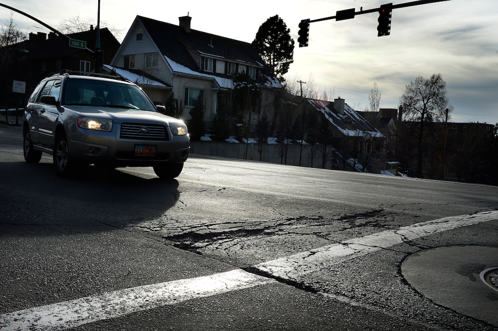 (Scott Sommerdorf   |  The Salt Lake Tribune)   
A car is about to drive over a section of the damaged road in the intersection of 100 South and University in Salt Lake City on Wednesday, Jan. 24, 2018.