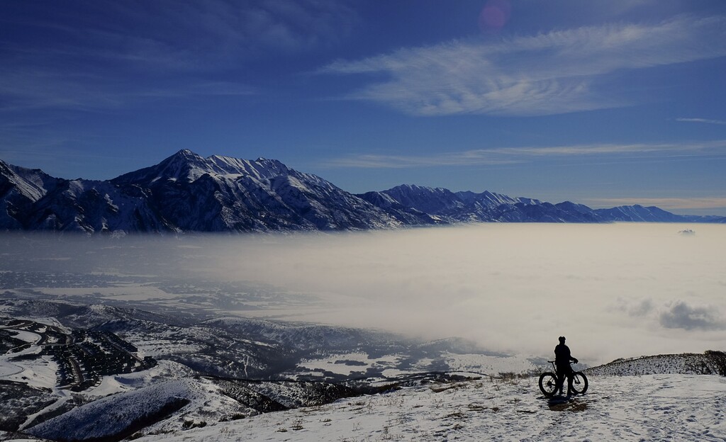 (Francisco Kjolseth | Tribune file photo)  In this February 2016 file photo, Jason Dunn of Draper seeks higher, cleaner air as he rides his bike to a peak overlooking the obscured Utah county as air quality continued to deteriorate with inversion conditions trapping cold air.