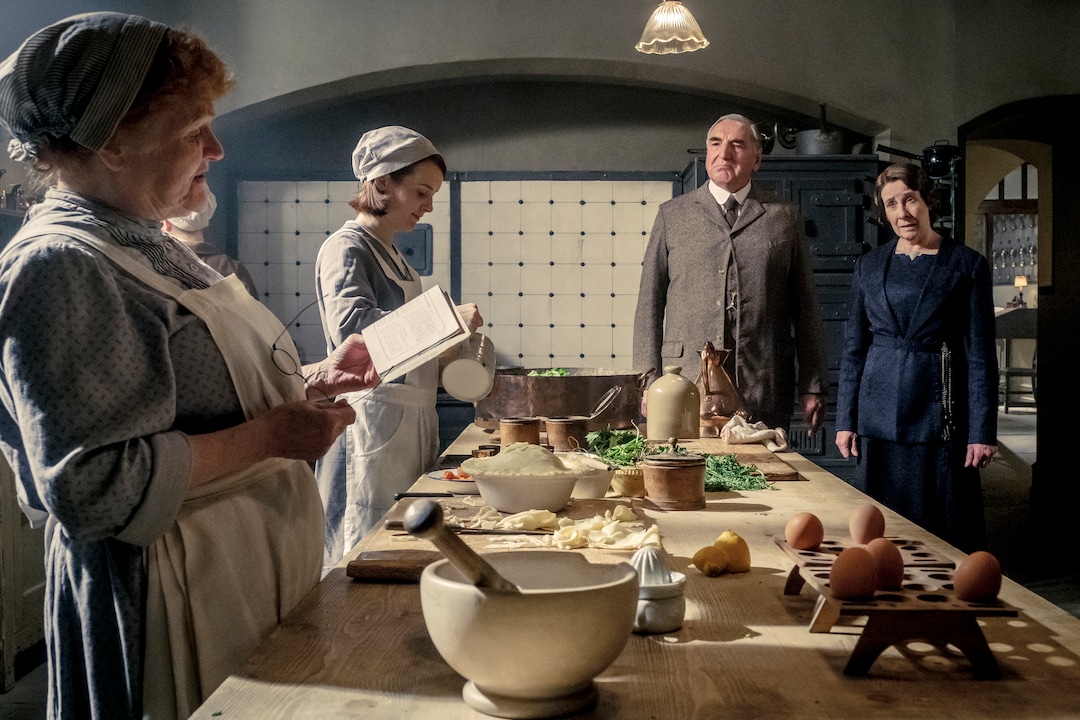 This image released by Focus Features shows, from left, Lesley Nicol as Mrs. Patmore, Sophie McShera as Daisy, Jim Carter as Mr. Carson and Phyllis Logas as Mrs. Hughes in "Downton Abbey". The film will be released Sept. 13, 2019, in the United Kingdom and on Sept. 20 in the United States. (Jaap Buitendijk/Focus Features via AP)