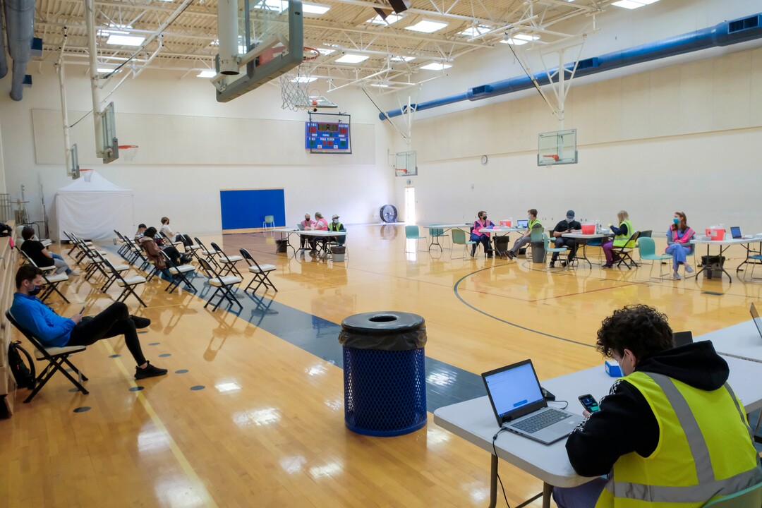 (Leah Hogsten | The Salt Lake Tribune) Students at Woods Cross High School, wait in the gymnasium for 15 minutes after receiving their first Pfizer vaccine at a pop-up clinic by Nomi Health,  April 27, 2021. County and regional health districts are setting up vaccination clinics in high schools, to get the COVID-19 vaccine to 16 and 17-year-olds.