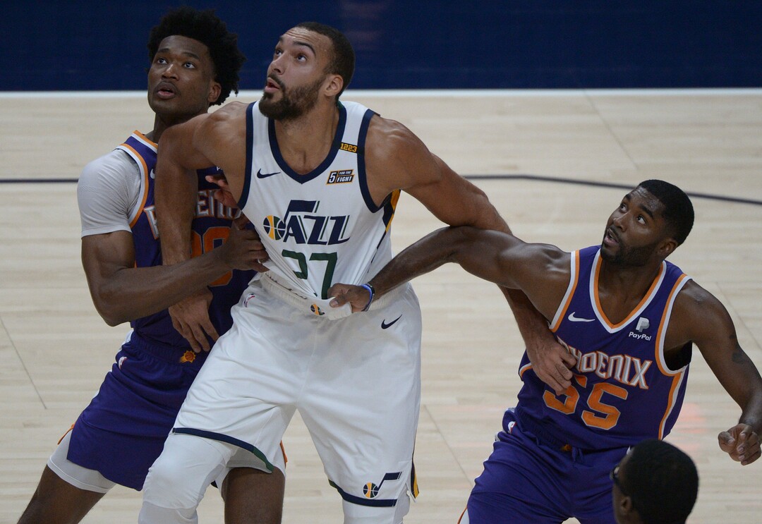 (Leah Hogsten  |  The Salt Lake Tribune) Utah Jazz center Rudy Gobert (27) battles Phoenix Suns center Damian Jones (30) and Phoenix Suns guard E'Twaun Moore (55) as the Jazz crack open their 2020-21 preseason with their second game against the Phoenix Suns, Dec. 14, 2020.
