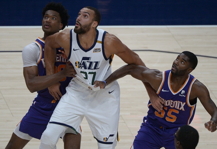 (Leah Hogsten | The Salt Lake Tribune) Utah Jazz center Rudy Gobert (27) battles Phoenix Suns center Damian Jones (30) and Phoenix Suns guard E'Twaun Moore (55) as the Jazz crack open their 2020-21 preseason with their second game against the Phoenix Suns, Dec. 14, 2020.