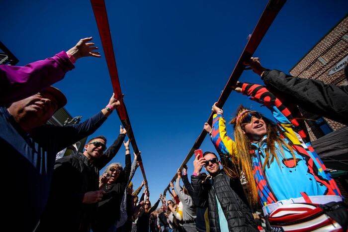 (Trent Nelson | The Salt Lake Tribune)
Participants lift up their skis on Park City’s Historic Main Street after drinking a shot at the annual Shot Ski event on Saturday Oct. 12, 2019.