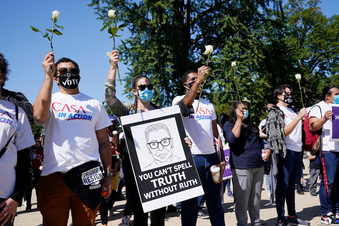 People pay respect in front of the Court as Justice Ruth Bader Ginsburg lies in repose under the Portico at the top of the front steps of the U.S. Supreme Court building on Wednesday, Sept. 23, 2020, in Washington. Ginsburg, 87, died of cancer on Sept. 18. (AP Photo/J. Scott Applewhite)