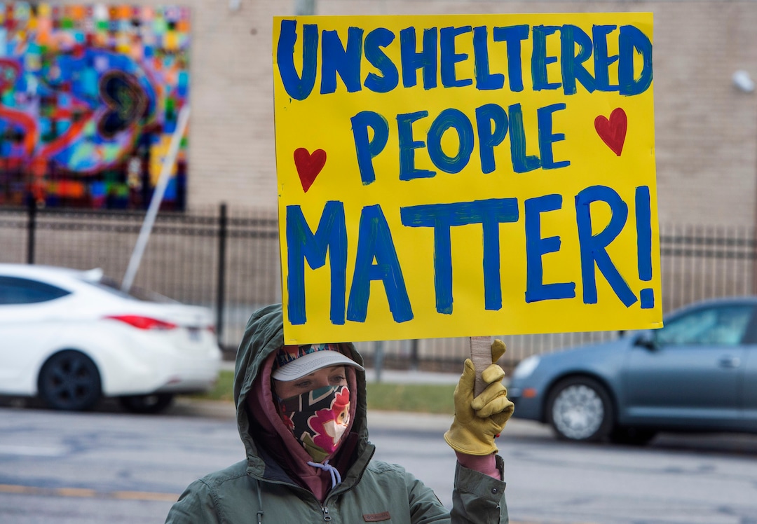 (Rick Egan | The Salt Lake Tribune)  Carrie Reilly joins Black Lives Matter and other groups, to protest the way the health department has been forcing people experiencing homelessness to move in the middle of a pandemic and the coldest time of the year, in front of the Salt Lake Public Health Center on Friday, Dec. 18, 2020.