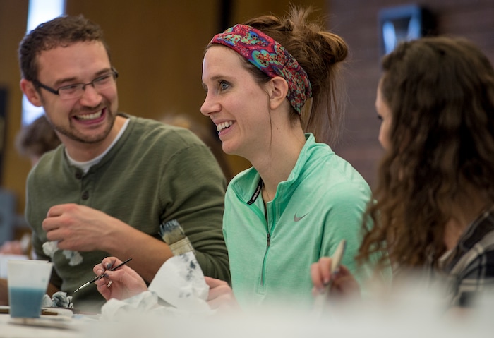(Leah Hogsten  |  The Salt Lake Tribune) Matt Stoker, from left, Kelly Starman and Jessica Tenney laugh at the speed and effortlessness that former television star painter Bob Ross shares as they try to follow along with the video during  Bob Ross Paint-Along class, Saturday, Jan. 6, 2018, at the Salt Lake City Public Library's Sweet Branch in the Avenues.