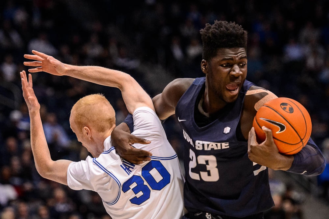 (Trent Nelson | The Salt Lake Tribune)  Utah State Aggies center Neemias Queta (23) gets tangled up with Brigham Young Cougars guard TJ Haws (30) as BYU hosts Utah State, NCAA basketball in Provo on Wednesday Dec. 5, 2018.