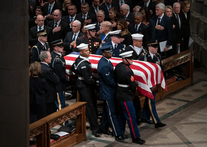 The flag-draped casket of former President George H.W. Bush is carried by a military honor guard past former President George W. Bush and wife Laura Bush, President Donald Trump, first lady Melania Trump, former President Barack Obama, Michelle Obama, former President Bill Clinton, former Secretary of State Hillary Clinton, former President Jimmy Carter, and Rosalynn Carter during a State Funeral at the National Cathedral, Wednesday, Dec. 5, 2018, in Washington. (AP Photo/Carolyn Kaster)