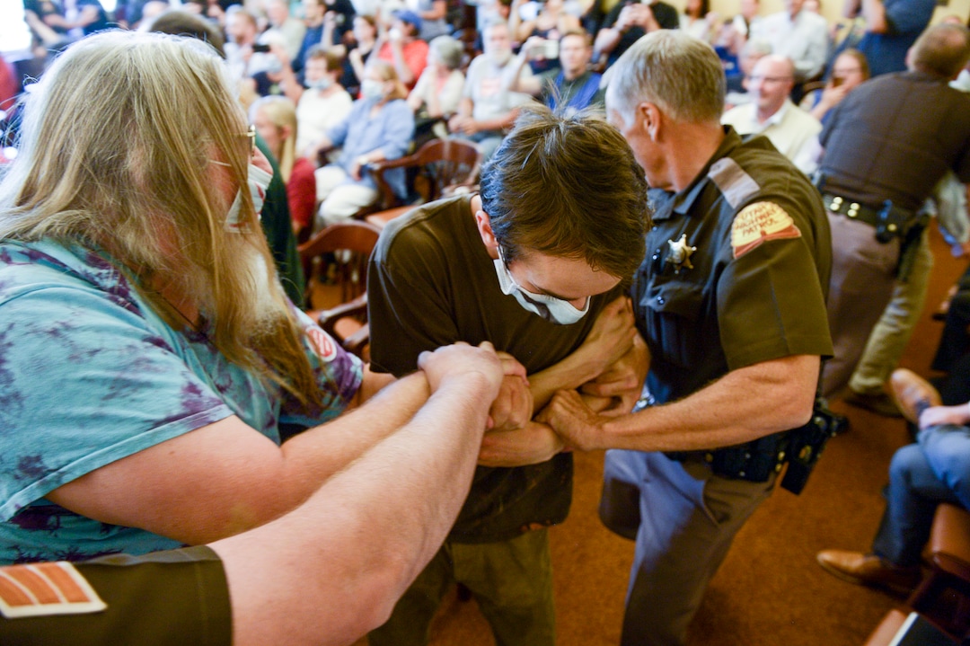 (Leah Hogsten  |  The Salt Lake Tribune) Opponents of the proposed inland port are escorted out of the Utah Inland Port Authority Board meeting by Utah Highway Patrol officers at the Capitol, June 5, 2019. The Inland Port Authority Board had to cancel its meeting last month after a group of protesters took over the meeting.