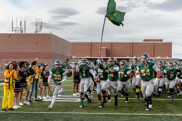 (Trent Nelson | The Salt Lake Tribune) Kearns players rush onto the field as Kearns hosts Lone Peak, high school football, Thursday September 14, 2017.