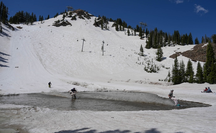 (Francisco Kjolseth  | The Salt Lake Tribune) A party atmosphere forms at the pond in Peruvian Gulch as Snowbird closes the book on the 2024-25 ski season on Monday, May 26, 2025. Snow and sun revelers took to the slushy slopes on Memorial Day as the resort was the last in the state to close.
