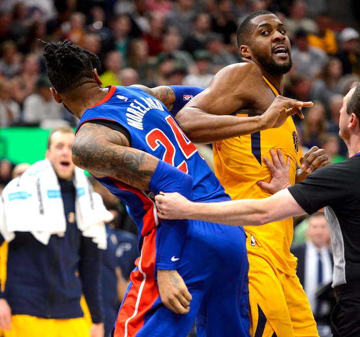 (Steve Griffin  |  The Salt Lake Tribune)  Detroit Pistons forward Eric Moreland (24) and Utah Jazz forward Derrick Favors (15) need to be separated by referee Scott Twardoski (52) as they get tangled up during the Utah Jazz versus Detroit Pistons at Vivint Smart Home Arena in Salt Lake City Tuesday March 13, 2018.