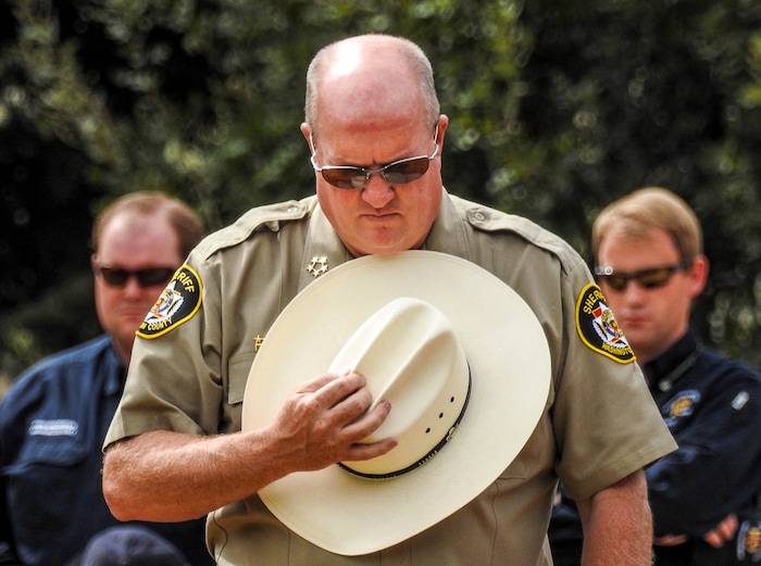 Trent Nelson  |  The Salt Lake TribuneWashington County Sheriff Cory Pulsipher bows his head at a memorial for the 13 (and 1 still missing) victims of a September 14th flash flood. The memorial was held in Maxwell Park in Hildale, Saturday September 26, 2015.