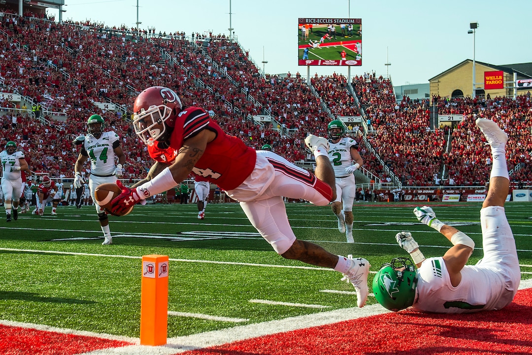 (Chris Detrick  |  The Salt Lake Tribune)  Utah Utes wide receiver Troy McCormick Jr. (4) leaps into the end zone past North Dakota Fighting Hawks defensive back Tanner Palmborg (21) during the game at Rice-Eccles Stadium Thursday, August 31, 2017. The play was called back due to a Utah foul. Utah Utes are leading North Dakota Fighting Hawks 17-9 at halftime. 