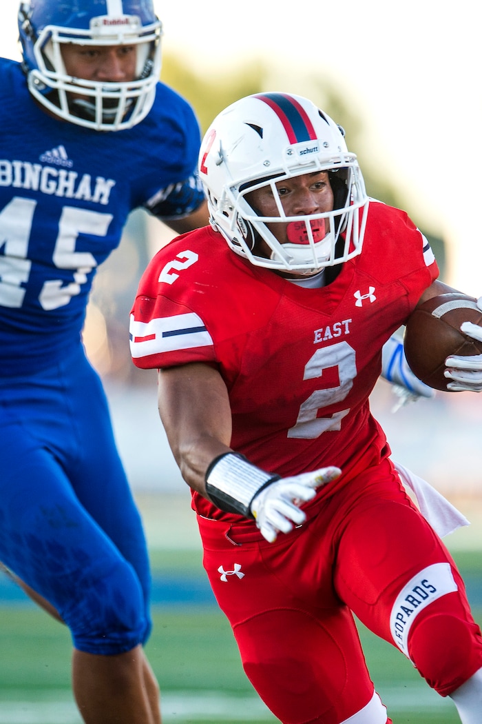 (Chris Detrick  |  The Salt Lake Tribune)  East's Sione Molisi (2) runs past Bingham's Junior Tafuna (45) during the game at Bingham High School Friday, August 25, 2017. Bingham is winning the game 24-17 at halftime. 