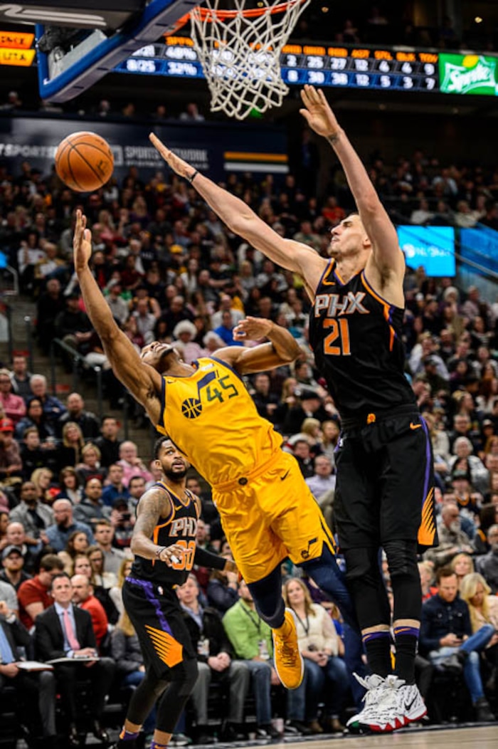 (Trent Nelson | The Salt Lake Tribune)  Utah Jazz guard Donovan Mitchell (45) tries to shoot around Phoenix Suns center Alex Len (21) as the Utah Jazz host the Phoenix Suns, NBA basketball in Salt Lake City, Wednesday Feb. 14, 2018.