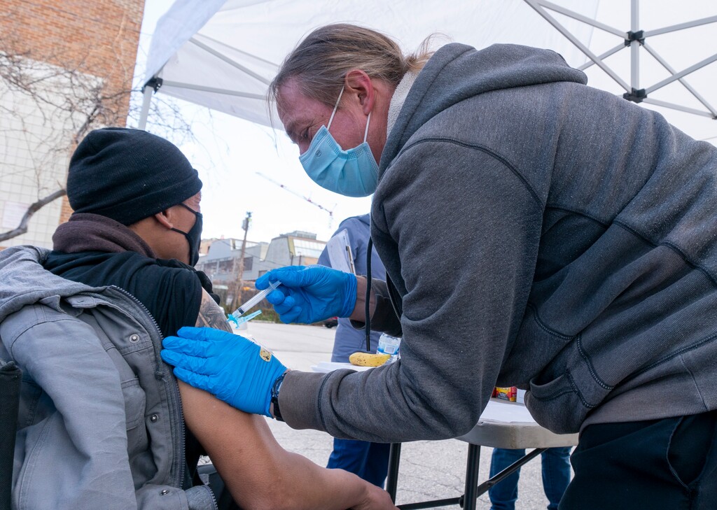 (Rick Egan | The Salt Lake Tribune) Jonathan Pimble, AEMT, administers a Covid -19 vaccination to Jerome Little, during a resource fair on Rio Grande Street, on Tuesday, March 30, 2021.