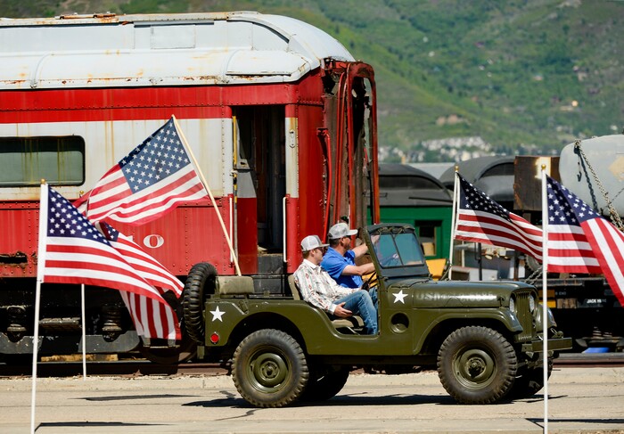 (Leah Hogsten  |  The Salt Lake Tribune) Two men in a WWII era Army jeep drive through the Heber City 2020 Memorial Day Drive By Tribute to remember and honor all of our military, past and present, men and women who serve or have served in our Armed Forces, May 25, 2020.