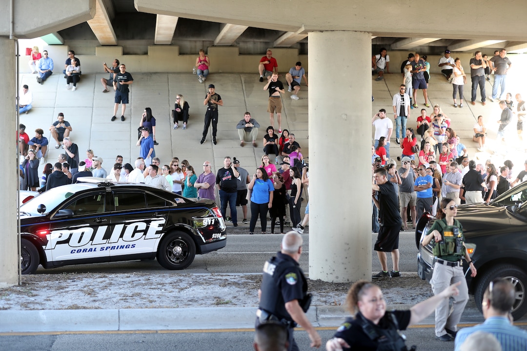 Waiting for word from students parents and family gather at Coral Springs Drive and the Sawgrass Expressway just south of the campus following a shooting at Marjory Stoneman Douglas High School in Parkland, Fla., Wednesday, Feb. 14, 2018. (Amy Beth Bennett/South Florida Sun-Sentinel via AP)