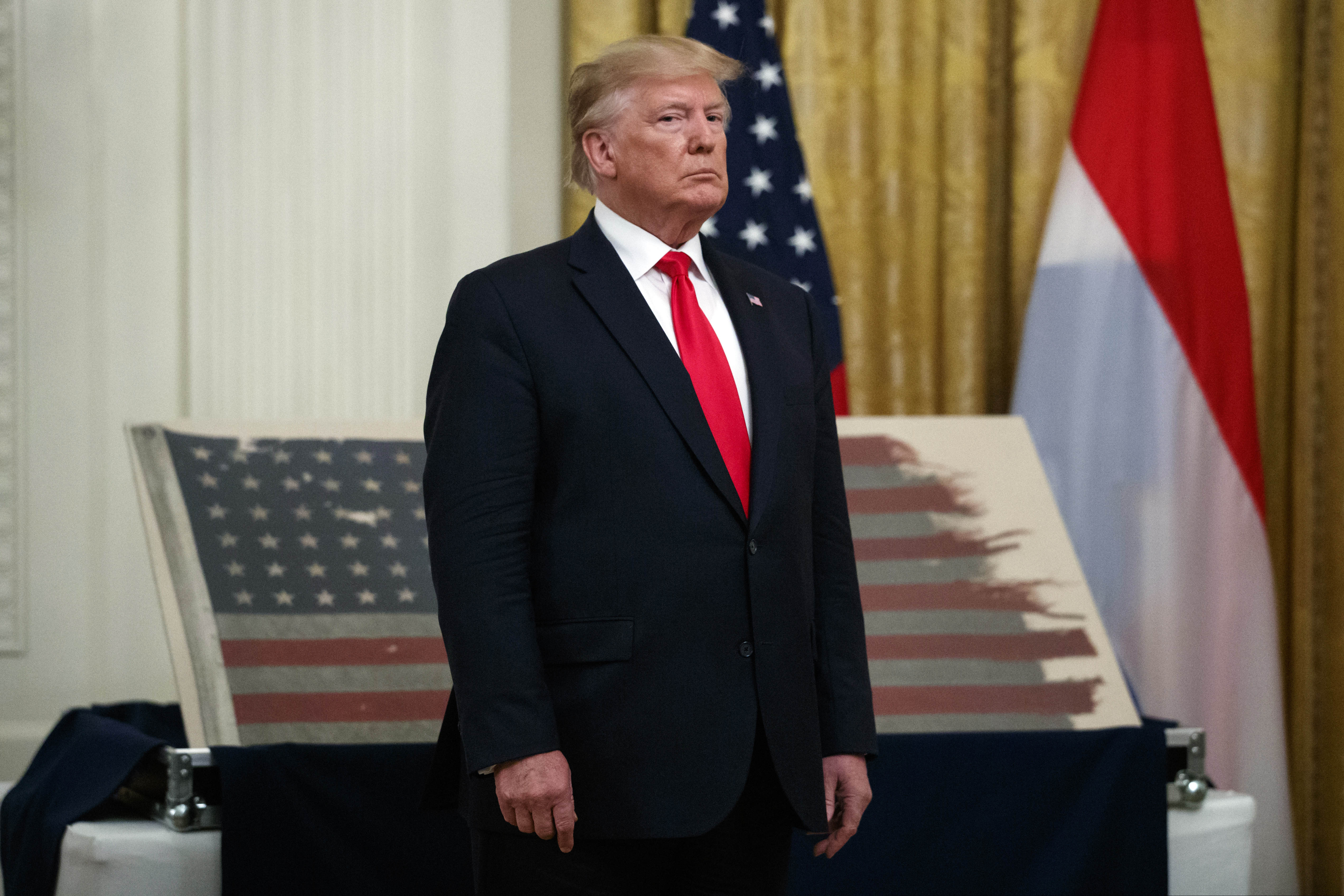 (Carolyn Kaster | AP file photo) President Donald Trump stands in front of a 48-star flag flown on a U.S. Naval vessel during the D-Day invasion during a ceremony in the East Room of the White House, Thursday, July 18, 2019, in Washington.