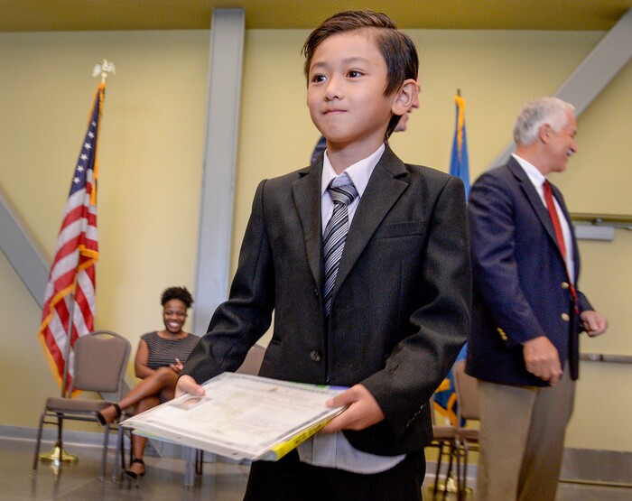 Leah Hogsten | The Salt Lake Tribune Long Wing Matthew Ko, 7, of Hong Kong grins after he is handed his citizenship papers. Participants, ages 5 to 22, representing 8 countries, spoke the oath of citizenship as America's newest citizens during a youth naturalization ceremony at the Viridian Event Center in West Jordan, Monday, August 6, 2018.