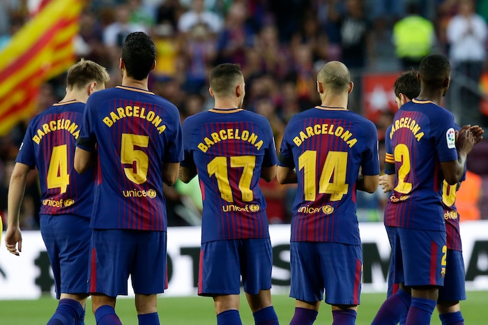 Barcelona players applaud after observing a minute of silence for the victims of the van attacks before a La Liga soccer match between Barcelona and Betis at the Camp Nou stadium in Barcelona, Spain, Sunday, Aug. 20, 2017. Security was stepped up for the match after a terror attack that killed 14 people and wounded over 120 in Barcelona and police put up scores of roadblocks across northeast Spain on Sunday in hopes of capturing a fugitive suspect at large following the vehicle attack. Barcelona players are all wearing shirts with 'Barcelona' on their backs tonight, rather than their names to pay homage to the van attack victims. (AP Photo/Manu Fernandez)