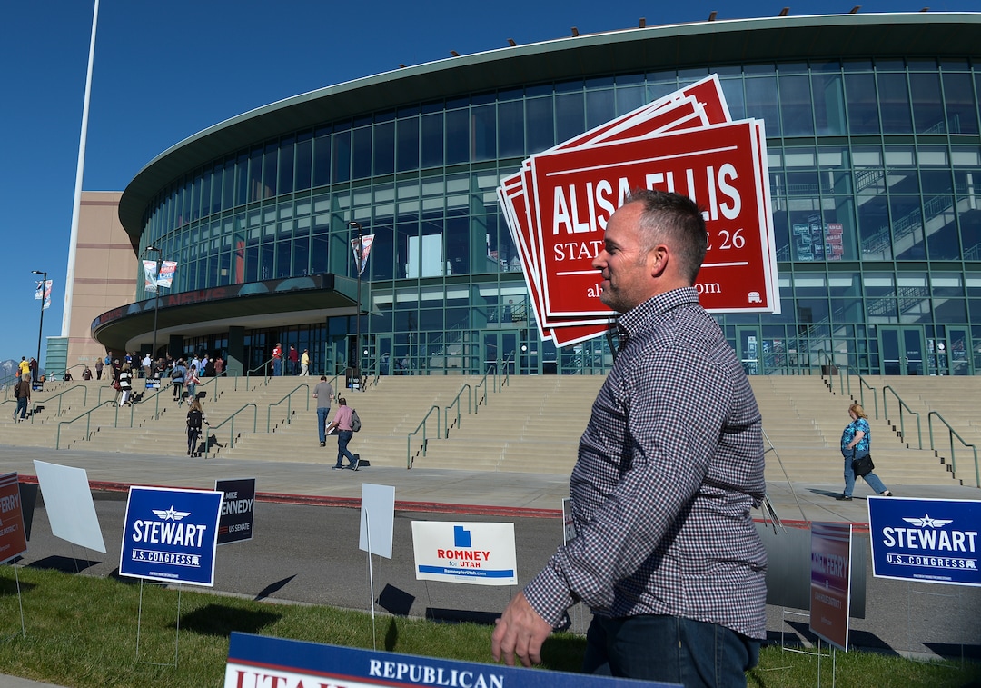 (Leah Hogsten  |  The Salt Lake Tribune) Dan Ellis of Heber carries signs for his wife Alisa Ellis, a candidate for State Senate 26 at the Utah Republican Nominating Convention Saturday, April 21, 2018 at the Maverik Center.