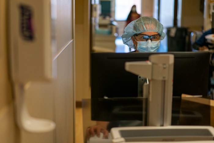 Team Rubicon volunteer Cindy Robison, a U.S. Air Force veteran and nurse from Colorado Springs, Colo., works in the emergency room at the Kayenta Health Center on the Navajo reservation in Kayenta, Ariz., on April 18, 2020. Team Rubicon is helping with medical and emergency room operations here as cases of COVID-19 surge. The reservation has some of the highest rates of coronavirus in the country. (AP Photo/Carolyn Kaster)