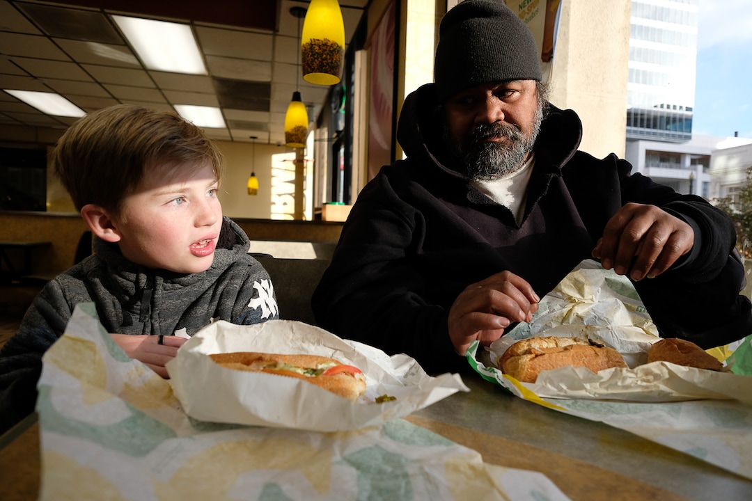 (Francisco Kjolseth  |  The Salt Lake Tribune) Ten-year-old Chase Hansen shares a meal with Viliami Taufalele, who says he has been homeless since 1999, as Chase and his father John spend time with people experiencing homelessness in an effort to connect with people on a personal level, learning and expressing empathy. On Monday, Dec. 16, 2019, Chase says "today is all about you, and hearing about you," as he has interviews Taufalele on a wide range of topics in an effort to make everyone feel "awesome."