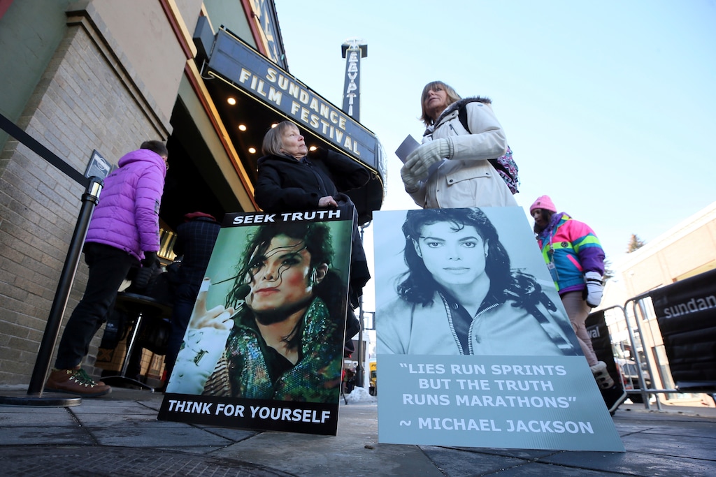FILE- In this Jan. 25, 2019, file photo Brenda Jenkyns, left, and Catherine Van Tighem who drove from Calgary, Canada stand with signs outside of the premiere of the "Leaving Neverland" Michael Jackson documentary film at the Egyptian Theatre on Main Street during the 2019 Sundance Film Festival in Park City, Utah. Jackson accusers Wade Robson and James Safechuck say that the Sundance Film Festival is first time they've ever felt public support for their allegations the King of Pop molested them. The documentary which premiered at the festival in January, and will air on HBO in two parts on March 3 and 4, chronicles how their lives intersected with Jackson's. (Photo by Danny Moloshok/Invision/AP, File)