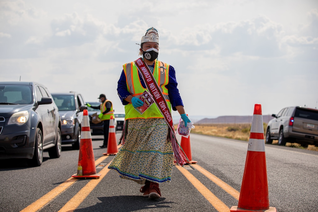 (Sharon Chischilly | The New York Times) Shaandiin Parrish, Miss Navajo Nation, hands out homemade masks, hand sanitizer, and information pamphlets at a checkpoint in Chinle, Ariz., on Aug. 20, 2020. The pandemic is now spread so widely across the country that any number of cities and states might now be considered the worst off, depending on the measurement used.