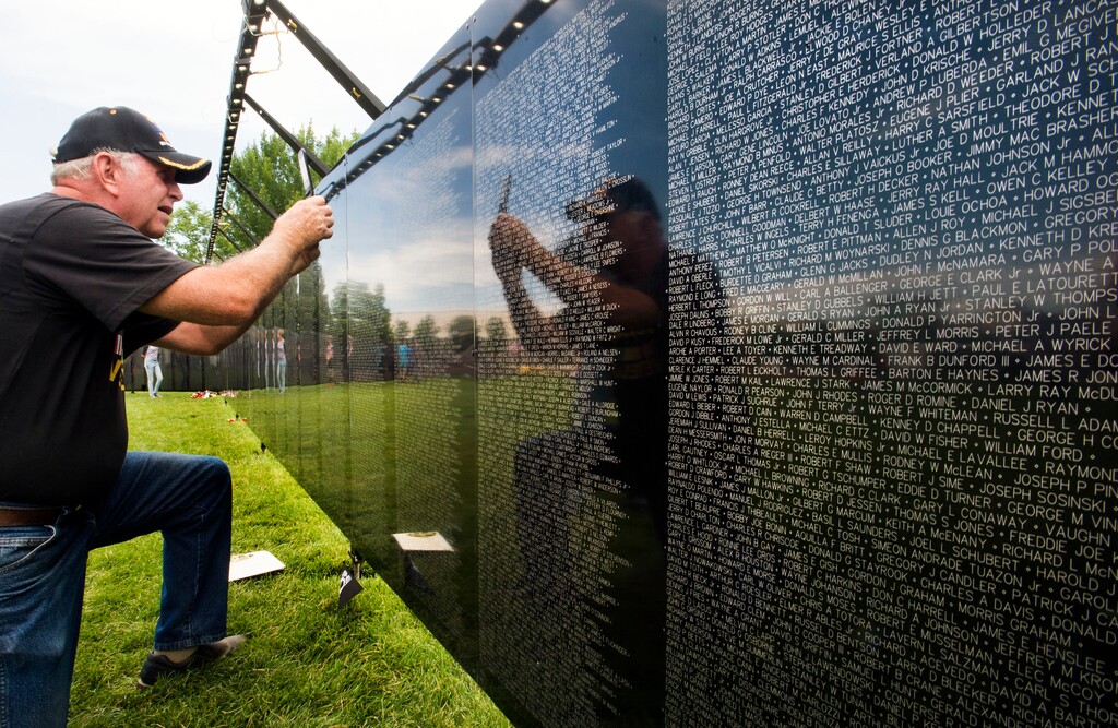Steve Griffin / The Salt Lake TribuneVietnam Veteran Don Ipson, originally from Draper, Utah is reflected in the The Wall That Heals as he takes a picture to the name of one of his best friends, Bravie Soto, as he visits the half-scale traveling replica of the Vietnam Veterans Memorial Wall located in Washington, DC. on display at Centennial Park in West Valley City Friday July 1, 2016. Ipson and Soto were with the 9th Infantry from 1966-1968 and had a tour in Vietnam from December 1966 to December 1967 in the Mekong Delta of South Vietnam. Ipson who met Soto in basic training at Fort Riley, Kansas said when he learned of Soto's death on Sept. 5, 1967 it was the worst day of his life. The wall will be open 24 hours a day, allowing the public to attend and honor those who gave their lives serving our country around the clock. The Wall That Heals is approximately 250 feet in length, and like the original Memorial is erected in a chevron-shape. The replica is constructed of powder-coated aluminum, supported by an aluminum frame, and is made up of 24 individual panels.
