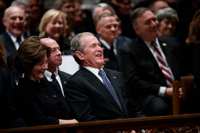 Former President George W. Bush and Laura Bush share a laugh as a story is told about his father, former President George H.W. Bush, during a State Funeral at the National Cathedral, Wednesday, Dec. 5, 2018, in Washington. (AP Photo/Evan Vucci)