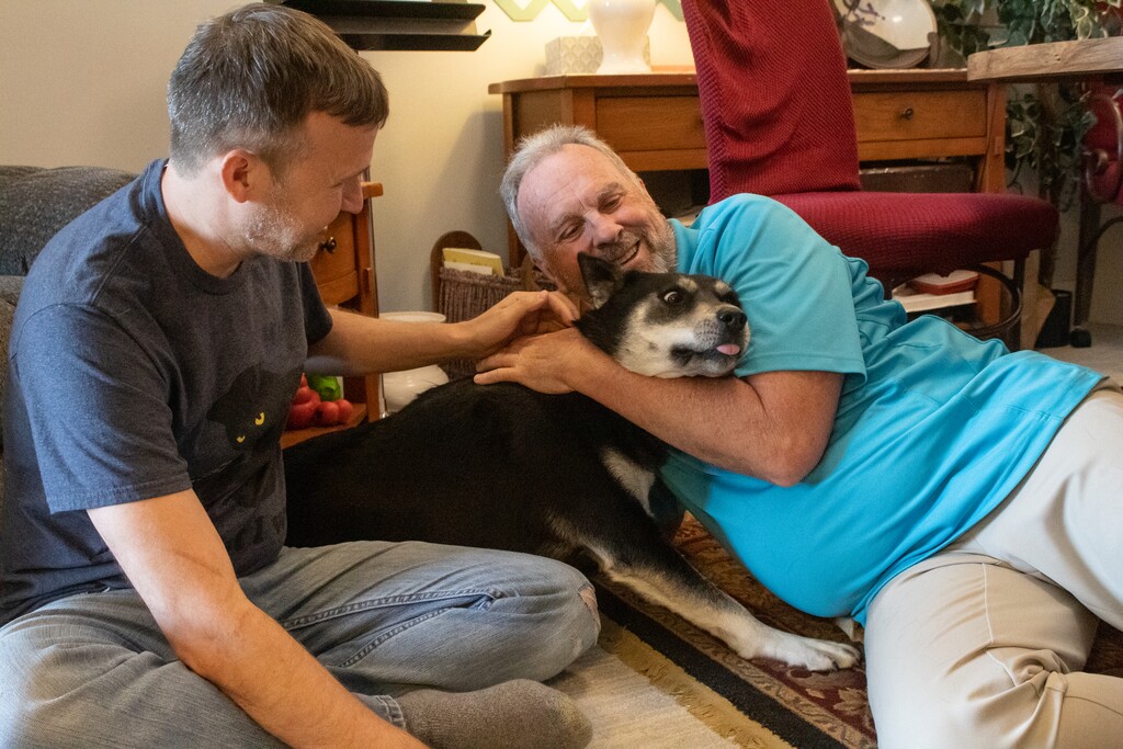 (Jordan Miller | The Salt Lake Tribune) Robert Roberts and Mike Packham hug Packham's adopted dog, Sam, at his home in Taylorsville on Tuesday, June 15, 2021.