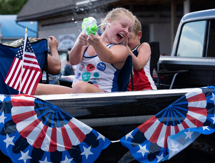 (Rick Egan | The Salt Lake Tribune) 
Kids armed with squirt guns dodge water balloons during the Pioneer Day Parade in Panguitch, on Saturday, July 23, 2022.