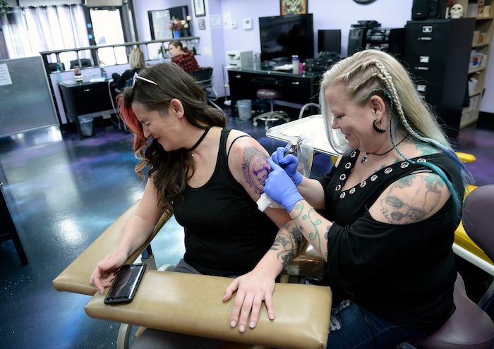 (Al Hartmann  |  The Salt Lake Tribune) 	
Terrina Francis, tatoo artist and owner of Fallen Angel Tattoo, is Salt Lake's only all-women tattoo studio.  She works on a personal tattoo for Shannon Gibbs, left.  Gibbs squints in momentary pain as she hits a senstivie part of her arm.   The design is an old-fashioned cameo skull that she has thought about and wanted for four years.   Francis also offers to tattoo over scars and disfigurements due to domestic violence, breast cancer, and burns.   The shop offers a place where women can feel comfortable about getting tattooed in a very male-dominated field. 