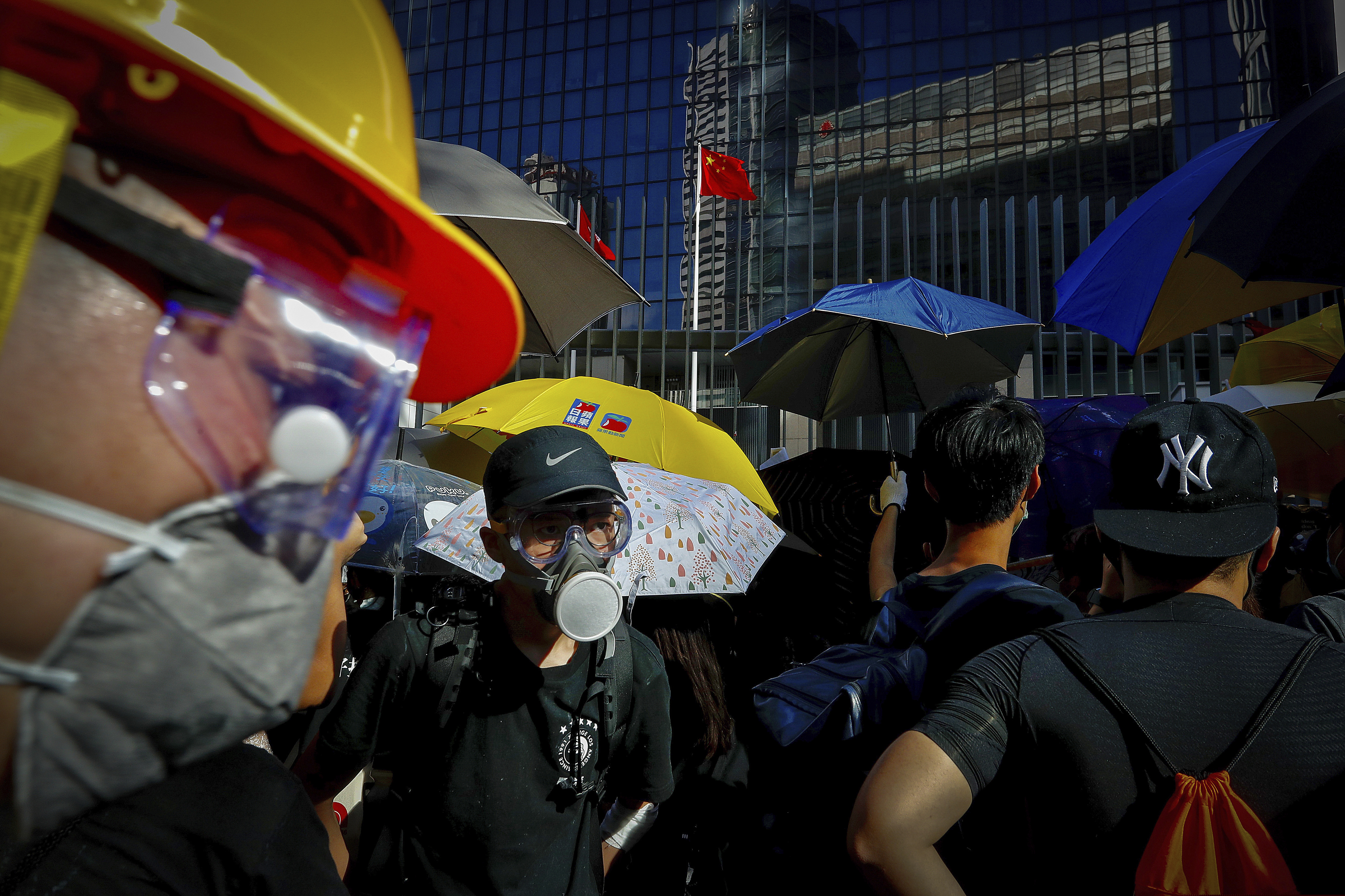 (Vincent Yu | AP Photo) Protesters wearing protective gear gather outside the Legislative Council in Hong Kong, Monday, July 1, 2019. Combative protesters tried to break into the Hong Kong legislature Monday as a crowd of thousands prepared to start a march in that direction on the 22nd anniversary of the former British colony's return to China.