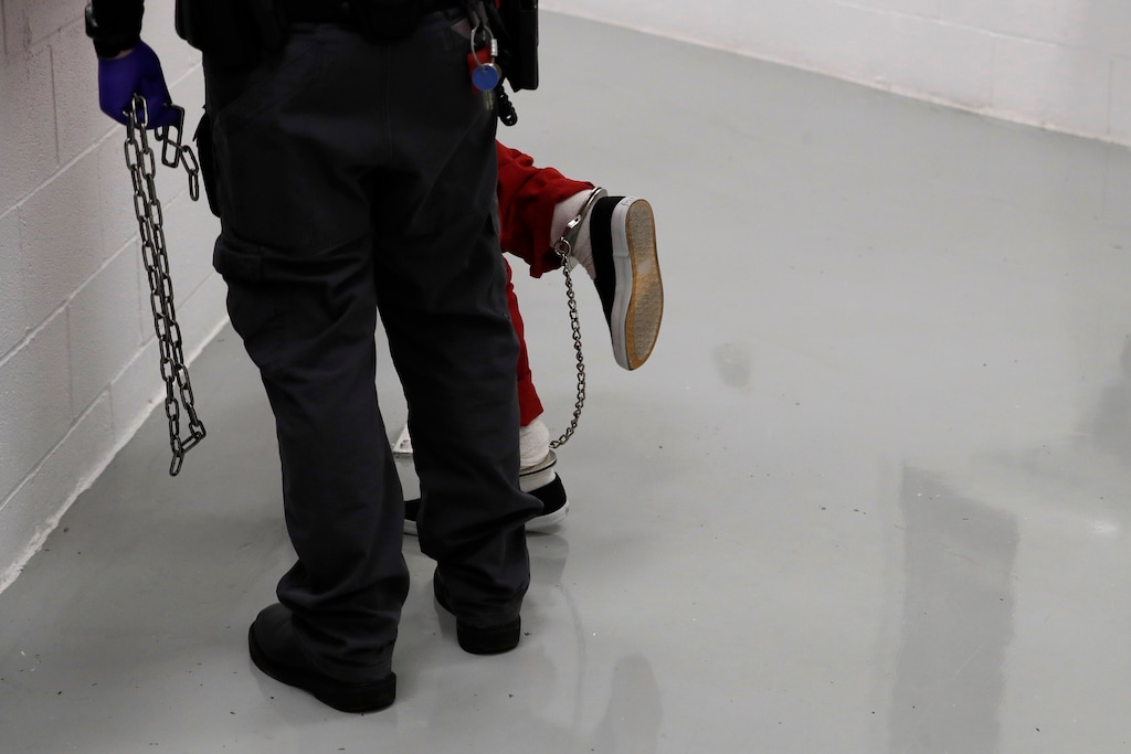 A detainee is placed in leg and arm shackles by a guard during a media tour at the U.S. Immigration and Customs Enforcement (ICE) detention facility Tuesday, Sept. 10, 2019, in Tacoma, Wash. (AP Photo/Ted S. Warren)