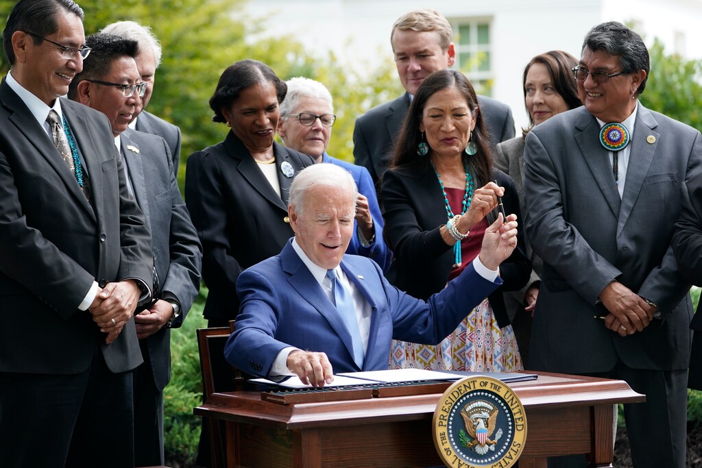 (Susan Walsh | AP) President Joe Biden hands a pen to Interior Secretary Deb Haaland as he signs a proclamation on the North Lawn at the White House in Washington, Friday, Oct. 8, 2021, during an event announcing that his administration is restoring protections for two sprawling national monuments in Utah that have been at the center of a long-running public lands dispute, and a separate marine conservation area in New England that recently has been used for commercial fishing.