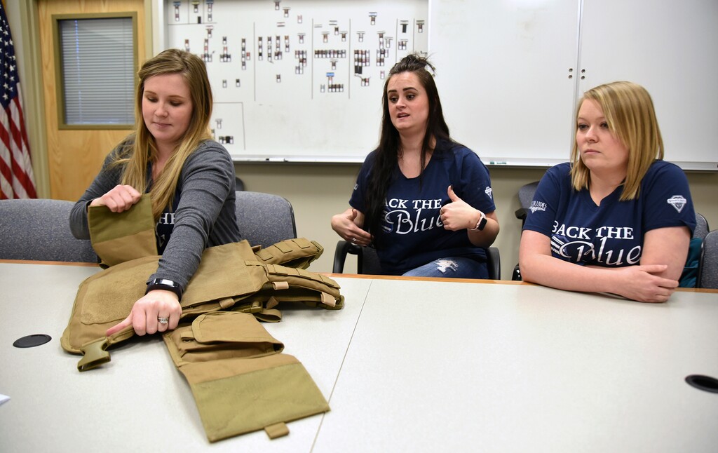 (Sarah Welliver | Standard-Examiner | The Associated Press) In a Tuesday, Jan. 16, 2018 photo, Lydia Hebdon, left, pulls open part of the Spartan armor vest as fellow Blue Line Ladies Foundation board members Aly Ward, center, and Anna McEwan, right, talk about the groups fundraising efforts to equip Utah law enforcement with the vests, inside Weber County Sheriff's Department in Ogden.