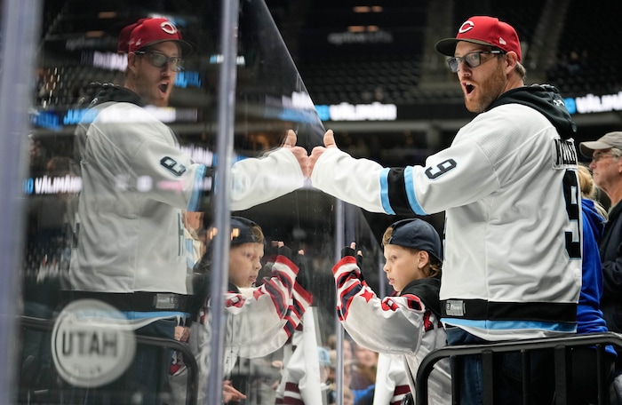 (Francisco Kjolseth | The Salt Lake Tribune) Evan Kynaston and his son Kayden, 7, cheer on the Utah Hockey Club as they warm up for their game against the Washington Capitals during an NHL hockey game at the Delta Center in Salt Lake City on Monday, Nov. 18, 2024.