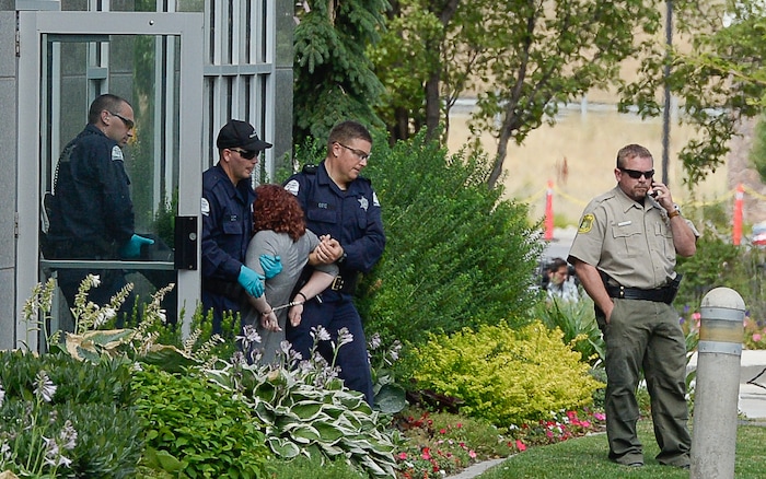 (Francisco Kjolseth  |  The Salt Lake Tribune)  Activists are escorted out of a building where they staged a protest against a private prison company with contracts to hold undocumented immigrants on Thursday, July 12, 2018, at the headquarters of Management and Training Corporation in Centerville.