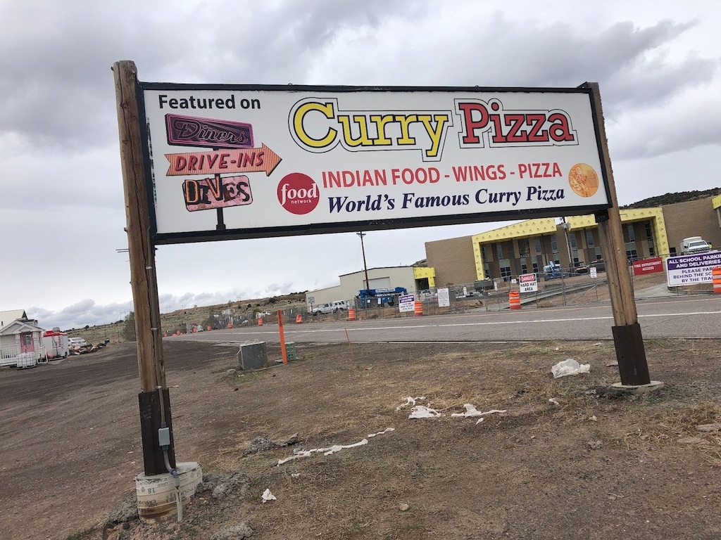 (Kolbie Peterson  |  The Salt Lake Tribune) A weathered sign leads travelers to Curry Pizza in Bicknell, west of Capitol Reef National Park in south-central Utah.