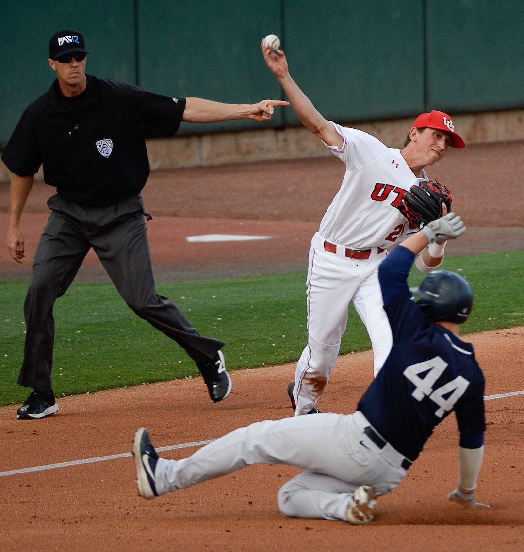 (Francisco Kjolseth  |  The Salt Lake Tribune)  Utah's Chase Fernlund throws to first as Brock Hale slides in as Utah and BYU renew their rivalry on the baseball diamond as they battle it out at Smith's Ballpark in Salt Lake City on Tuesday, May 14, 2019.