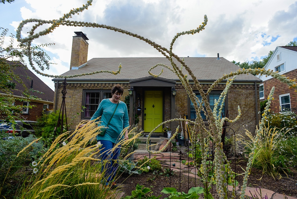(Francisco Kjolseth | Tribune file photo)  Bea Layton checks out how some of the plants have grown outside the home she lived in for 22 years after doing extensive xeriscaping that has been maintained by the current owner.