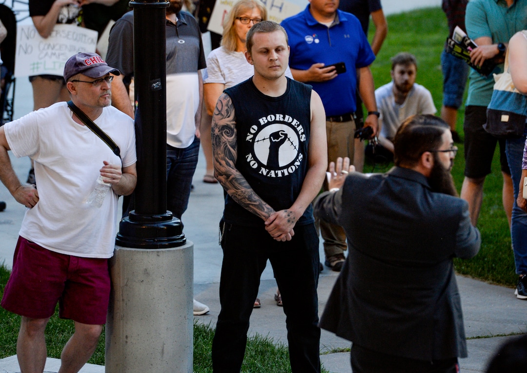 (Leah Hogsten  |  The Salt Lake Tribune) Jacob Isbell, right, tries to engage Sebastian Livingston, left, during Lights for Liberty: A Vigil to End Human Detention Camps at Washington Square, July 12, 2019 to protest the inhumane conditions faced by refugees.