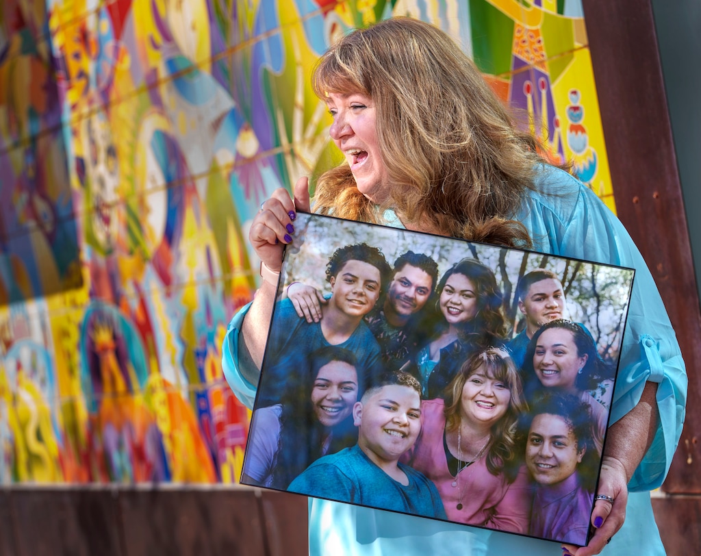 (Leah Hogsten | The Salt Lake Tribune) In Glendale, Roxanne Langi holds a photograph of herself with her eight children — four graduated from East High School and four graduated from West High School. Langi supports the idea of a building a new high school on the west side of Salt Lake City. Pictured front, left to right, Atelaite, Steven, Roxanne, Inoke and in back, Molonai, Siosaia, Ana, Nifai and Amber Langi.